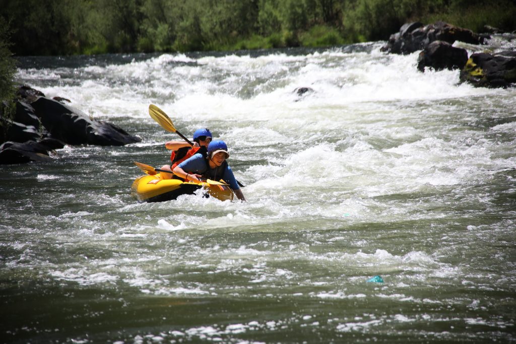 Boy Scouts navigating through Otter's Playpen Rapid on the Lower Klamath in inflatable kayaks.
